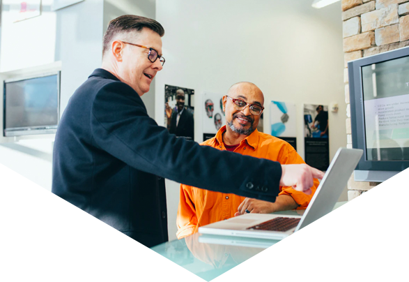 Two men in office looking at laptop screen