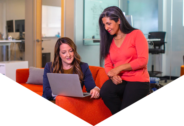 Two women in office looking at laptop screen