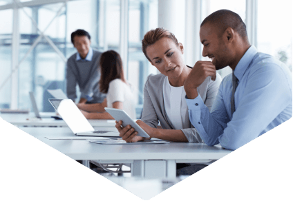 two people in an office looking at a tablet