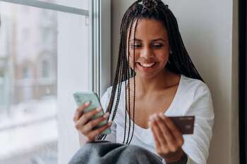 Woman holding mobile phone and credit card