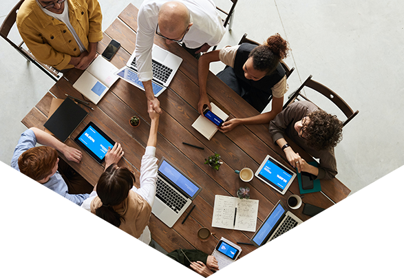 Group of people on laptops sat around desk