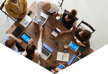 Group of people on laptops sat around desk