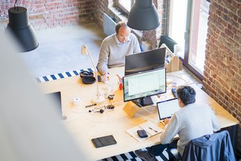 Aerial shot of two men working at desks in office