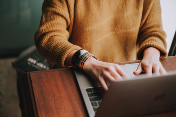 Person at desk typing on laptop