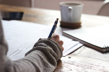 Person writing at desk