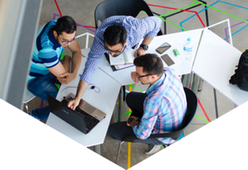 Three men sat at desk looking at laptop screen