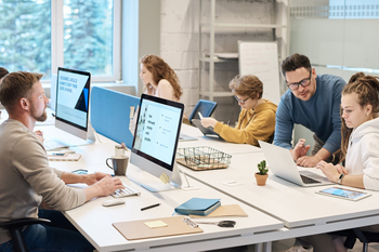 Group of colleagues working around desk in office